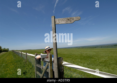 Walker auf der berühmten Kaninchenbau Website Watership Down in Hampshire berät eine Karte Stockfoto