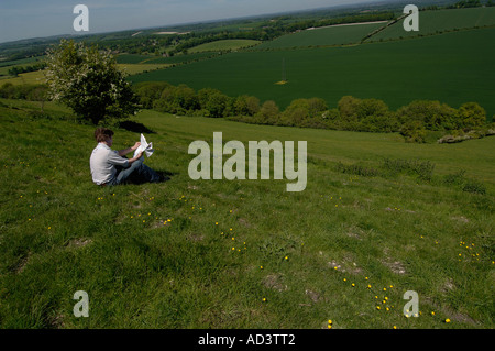 Walker auf der berühmten Kaninchenbau Website Watership Down in Hampshire berät seine Karte Stockfoto