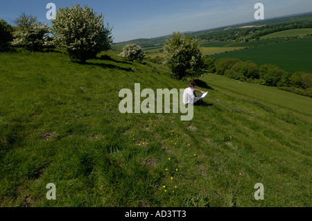 Walker auf der berühmten Kaninchenbau Website Watership Down in Hampshire berät seine Karte Stockfoto