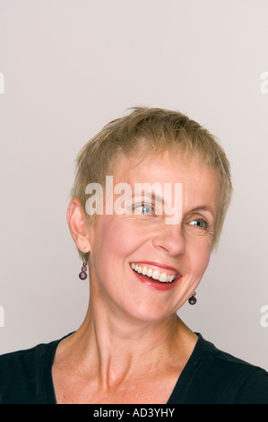 Reife Frau lächelnd während wegsehen. Stockfoto