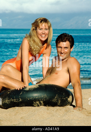 Paar am Strand mit innertube Stockfoto