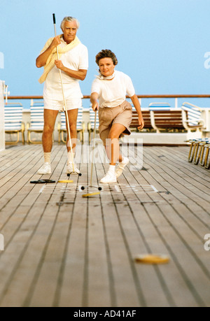 Älteres Paar spielen Shuffleboard auf Kreuzfahrtschiff Stockfoto