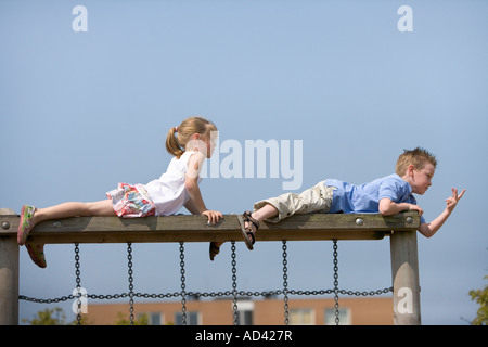 Mädchen und jungen am Ende eine Kletterstange auf dem Spielplatz Stockfoto
