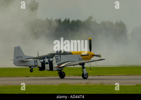 Ein amerikanischer WW2 Mustang Kämpfer auf einer Rauch-bedeckten Startbahn abheben. Stockfoto