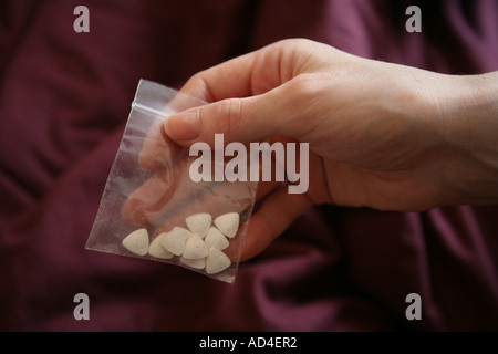 Dreieck geformte weiße Ecstasy-Drogen-Pillen oder Tabletten in einer kleinen Tasche. Stockfoto