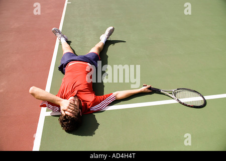 Ein Tennisspieler liegend auf dem Tennisplatz Stockfoto