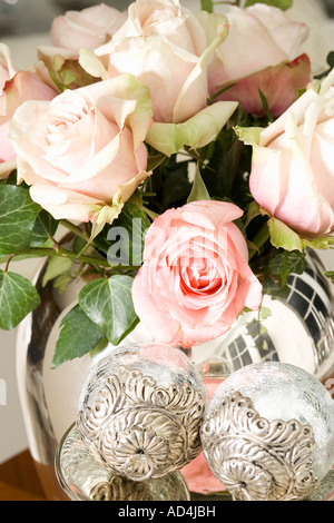 Ein Bouquet von blass rosa Rosen in einer Vase Silber Stockfoto