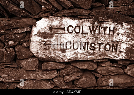 Einen alten Meilenstein gesetzt in einer Trockensteinmauer in Langdale im englischen Lake District Stockfoto