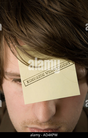 Ein Mann mit einem Klebstoff Hinweis auf seiner Stirn gestempelt "Eintrag verweigert" Stockfoto