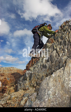 Eine Dame Kletterer absteigend einen steilen Abschnitt auf dem sehr schmalen und exponierten Crib Goch Grat in Nord-Wales Stockfoto