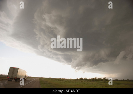 Gewitterwolken über eine ländliche Landschaft und einem Lastwagen auf der Autobahn Stockfoto