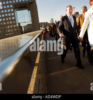 Am frühen Morgen Büroangestellte zu Fuß über die London Bridge mit einer London Bridge im Hintergrund 2007 arbeiten Stockfoto