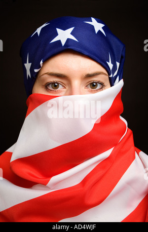 Muslimische Frau trägt eine amerikanische USA US-Flagge als eine Hijab Burka mit schwarzem Hintergrund Stockfoto