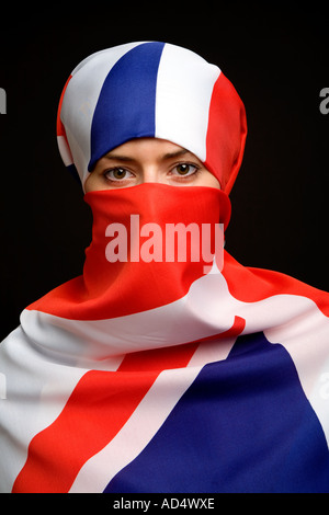 Muslimische Frau trägt ein Union Jack-Flagge als eine Hijab Burka mit schwarzem Hintergrund Stockfoto