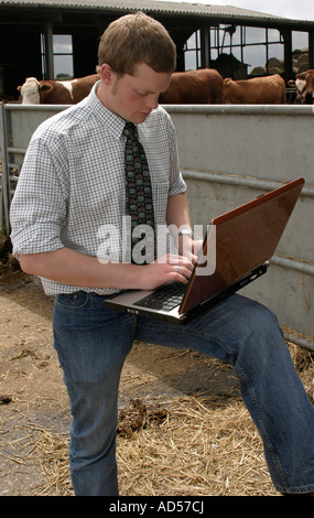 Ein junger Bauer, praktische Verwendung eines Laptop-Computers in der Landwirtschaft Stockfoto