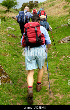 Gruppe von Wanderern auf Wanderweg zu Fuß bis steilen Hang in den schwarzen Bergen in der Nähe von Abergavenny Monmouthshire South Wales UK Stockfoto