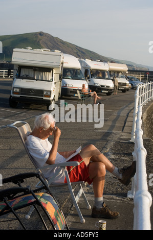 Eine Flotte von 4 vier Wohnmobile auf der Promenade Aberystwyth Ceredigion West Wales, mit einem Mann sitzen in einem Stuhl, Sommer, UK Stockfoto