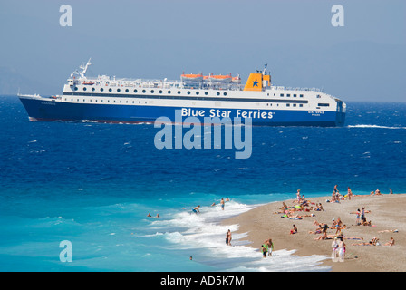 Horizontale Luftaufnahme von Urlaubern am Strand mit einem großen Passagier Fähre Segeln bei Sonnenschein übergeben Stockfoto