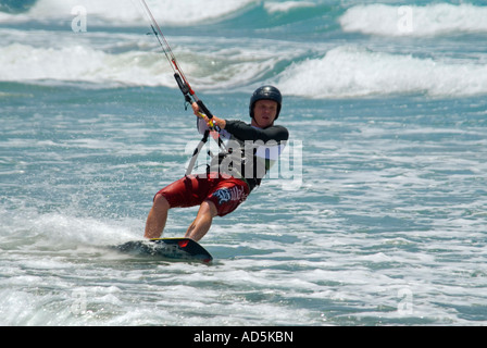 Horizontale Nahaufnahme von einem kaukasischen männlichen Kitesurfer in eine schiefe Lage krachend durch die Wellen Stockfoto