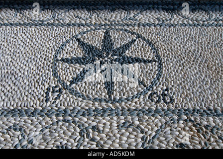 Horizontale nahe Kies ein traditioneller Mosaik aus 1906 auf der Stufe eines Ladens in Lindos. Stockfoto