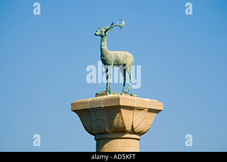 Horizontale Nahaufnahme der Hirsch Reh Statue auf einer hohen Säule am Eingang des Mandraki Hafen gegen ein strahlend blauer Himmel Stockfoto