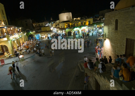 Horizontale erhöhten Weitwinkel von Menschen sitzen auf Schritte in dem beliebten Ippokratous Platz in der Altstadt von Rhodos in der Nacht. Stockfoto