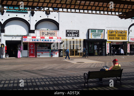 Mann, sitzend lesen Zeitung auf dem Boardwalk in Atlantic City, New Jersey USA Stockfoto