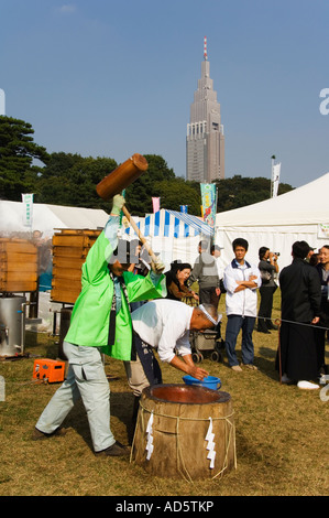 Japanischen Insel Honshu Tokio landwirtschaftliche Festival Gemüse Stand Männer Mochi Reis mit NTT Gebäude hinter Stockfoto