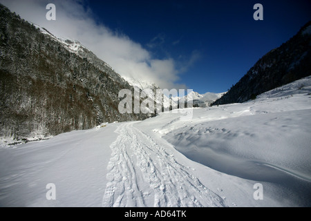 Schnee bedeckten Strecke zwischen zwei bewaldeten Bergen Stockfoto