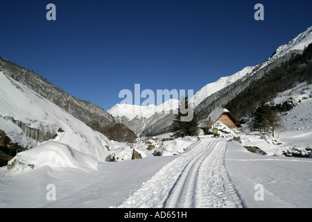 aufgenommenen Spur führt zu einem Holz-Chalet an der Unterseite des schneebedeckten Berges Stockfoto