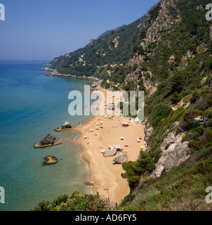 Luftbild mit Blick auf schiere Baum bedeckt Klippen fallen, sandigen Strand und Felsen unten Mirtiotissa Beach Korfu griechische Inseln Stockfoto