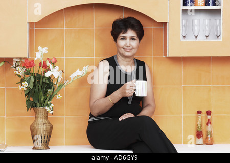 Porträt einer reifen Frau hält einen Becher Stockfoto