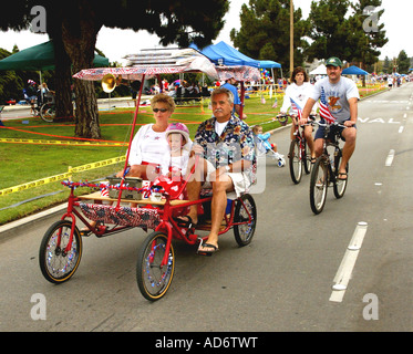 Familien-Fahrgeschäfte Zyklus dekoriert in rot weiß und blau 4. Juli Parade in Huntington Beach Kalifornien USA Stockfoto