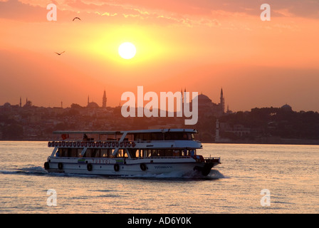 Fähre bei Sonnenuntergang über den Bosporus mit Aya Sofya (Hagia Sophia) in Istanbul, Türkei Stockfoto