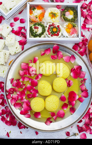 Erhöhte Ansicht eines Gerichtes indische Süßigkeiten mit Blütenblättern drumherum Stockfoto