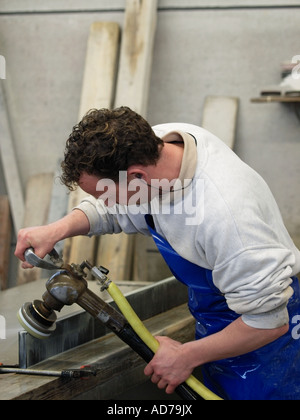 Mann, Polieren, rundet die Kanten eine Marmorplatte, die in einem Stock oder einer Küche Breda Niederlande verwendet wird Stockfoto