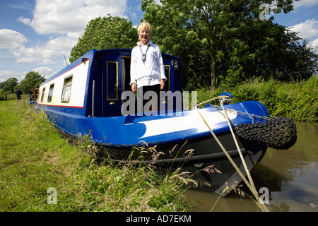 Mittlere gealterte Dame Bootsfahrer auf ihre Narrowboat auf dem North Oxford Kanal, Warwickshire Stockfoto