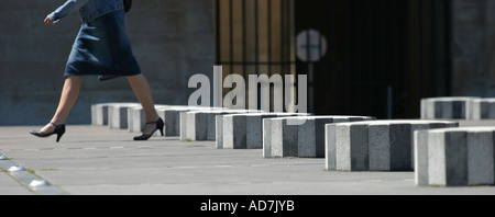 Frau zu Fuß durch Les Colonnes de Buren im Palais Royal Paris France Stockfoto
