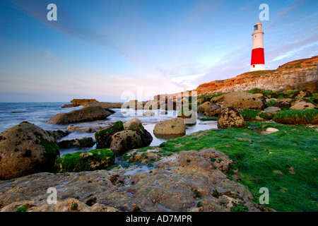 Portland Bill Leuchtturm in der Dämmerung aus dem vorland unter den tückischen Landspitze Felsen, die das Meer bei Ebbe Stockfoto