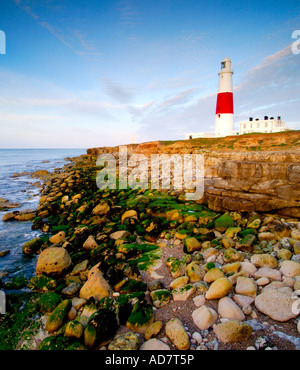 Portland Bill Leuchtturm in der Dämmerung von der Klippe über dem tückischen Landspitze Felsen an der Küste unten Stockfoto