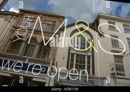 Marks & Spencer Zeichen in einem Fenster in Barnstaple, North Devon, mit Gebäuden reflektiert im Glas Stockfoto