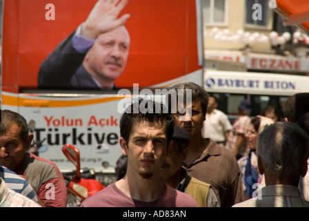Türkische Männer in Bergama mit politischen Wahlplakat der Ministerpräsident der Türkei Recep Tayyip Erdogan Stockfoto