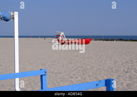 Leuchtend rote Rettungsboot und leere Rettungsschwimmer angehoben Stuhl am Strand von Cape May New Jersey USA Amerika Stockfoto