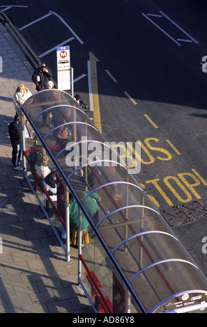 Menschen in Warteschlange für Bus an der Bushaltestelle Leeds Yorkshire uk Stockfoto