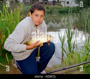 Young Boy mit seinem Fang von Karpfen. Stockfoto