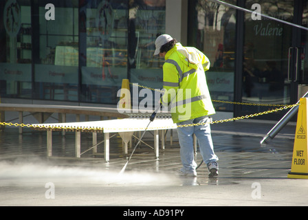 Hochdruckreiniger Maschine Wasser Spray Jet Reinigung Pflaster von Kaugummi & andere grot durch den Betreiber trägt hohe Sichtbarkeit Jacke London England Großbritannien Stockfoto