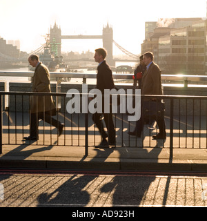 Am frühen Morgen Büroangestellte zu Fuß über die London Bridge mit Tower Bridge im Hintergrund arbeiten Stockfoto