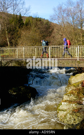 Brücke über den schnell fließenden Fluss Irfon Wanderer in der Nähe von Llanwrtyd Wells Powys Wales UK Stockfoto