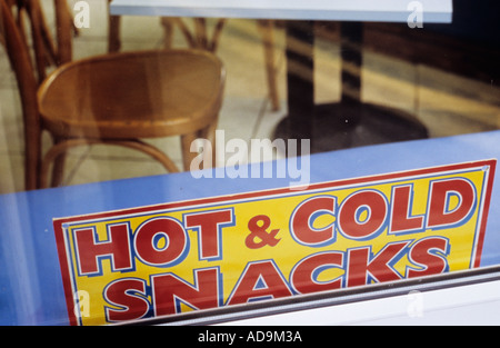 Fenster für ein Café oder Restaurant oder Restaurant mit Stühlen und Tisch sichtbar und auf dem Glas ein Zeichen besagt warme und kalte snacks Stockfoto