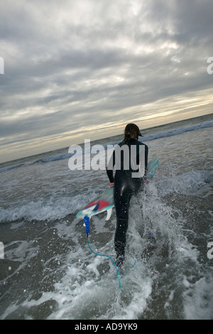 Junge Surfer Tauchen in Wellen auf seinem Brett, Rückansicht Stockfoto